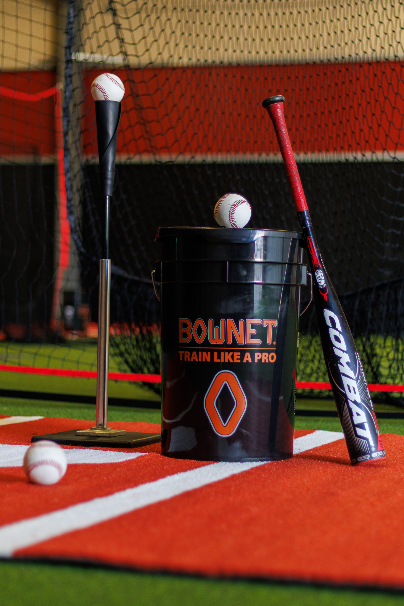 Batting tee, ball bucket, and bat ready at home plate